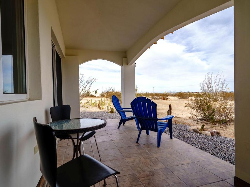 a patio with chairs and a table and a view of the desert at El Dorado Ranch Rental Studio Ross in Playa El Paraíso