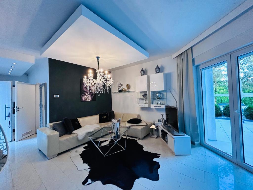 a living room with a couch and a chandelier at Dora Design House in Człuchów