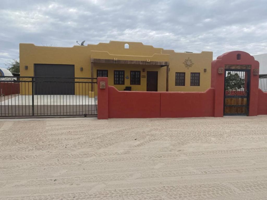 a building with a red fence in front of it at Casa Serenidad familiar escapade in San Felipe