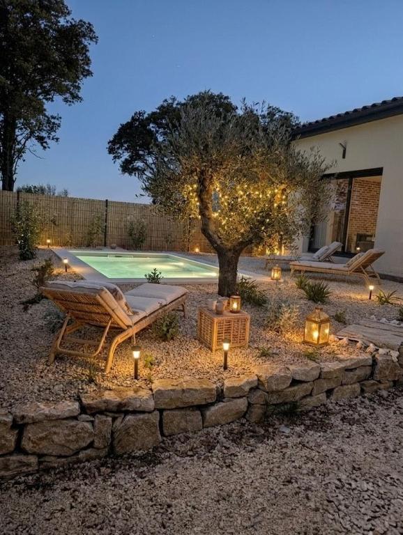 a patio with a tree and lights in a yard at Jardin de Sévigné à Grignan in Grignan