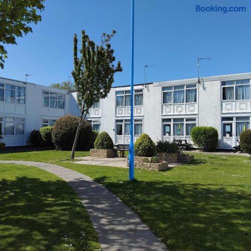 a large white building with a blue pole in the grass at Dawlish Warren Welcome family holiday park South Devon Willow villa Welcome2Warren in Dawlish Warren