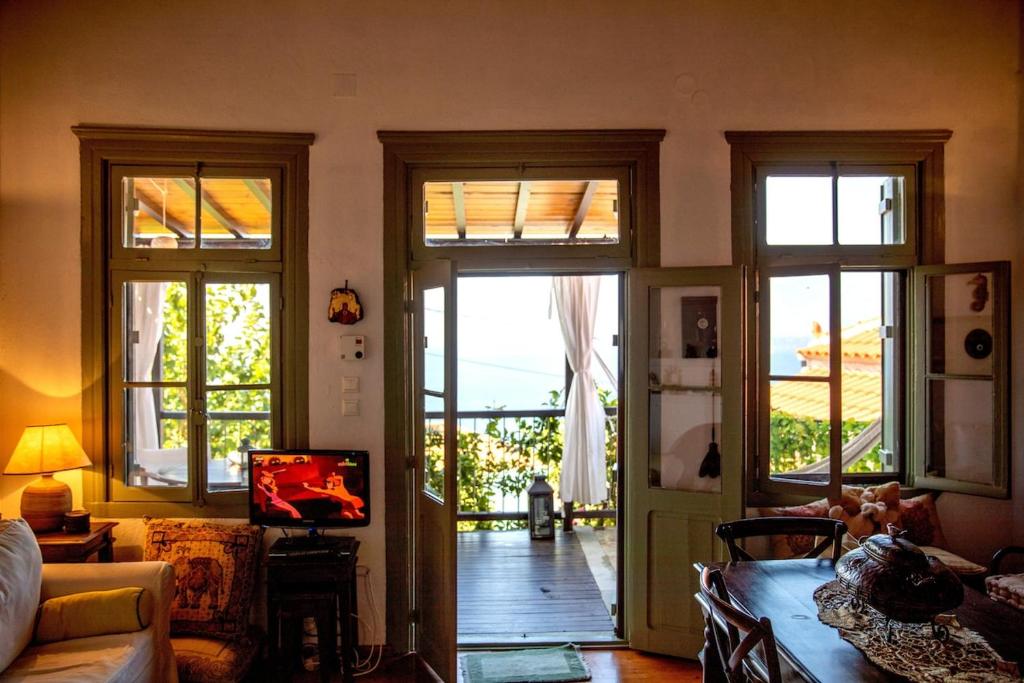 a living room with doors open to a patio at Olive Cottage in Skopelos Town