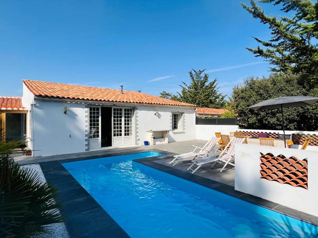 a villa with a swimming pool in front of a house at Longe 17 - élégante propriété avec deux maisons in Longeville-sur-Mer