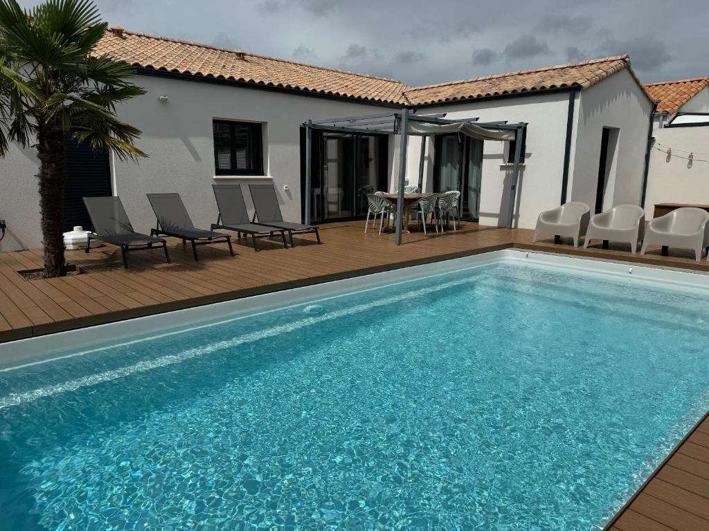 a swimming pool in front of a house at Quai Ouest - élégante maison avec piscine in Saint-Vincent-sur-Jard