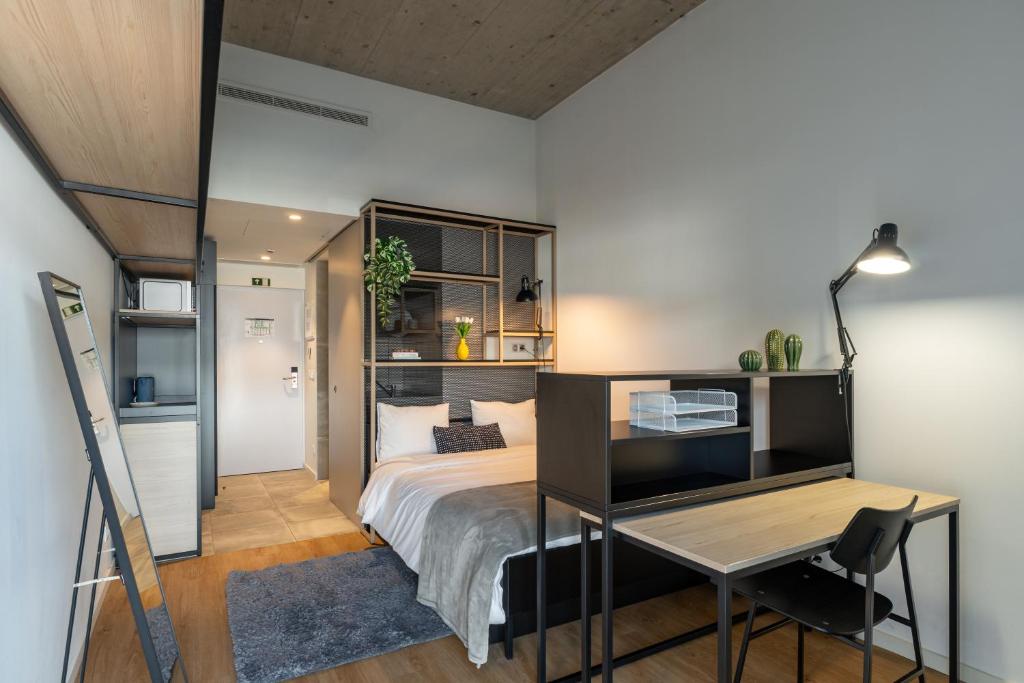 a bedroom with a bed and a desk and a desk at Codomo Living Carcavelos Lombos in Carcavelos