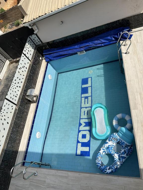 a swimming pool with a sign that says end at Tombell Homes in Ibadan