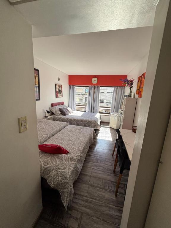 a hotel room with two beds and a desk at Departamento en Microcentro (Obelisco) in Buenos Aires