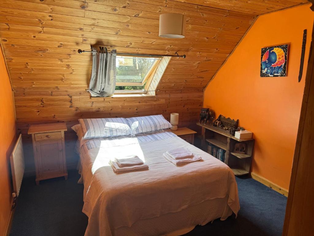 a bedroom with a bed in a wooden cabin at Kermor B&B in Claddaghduff