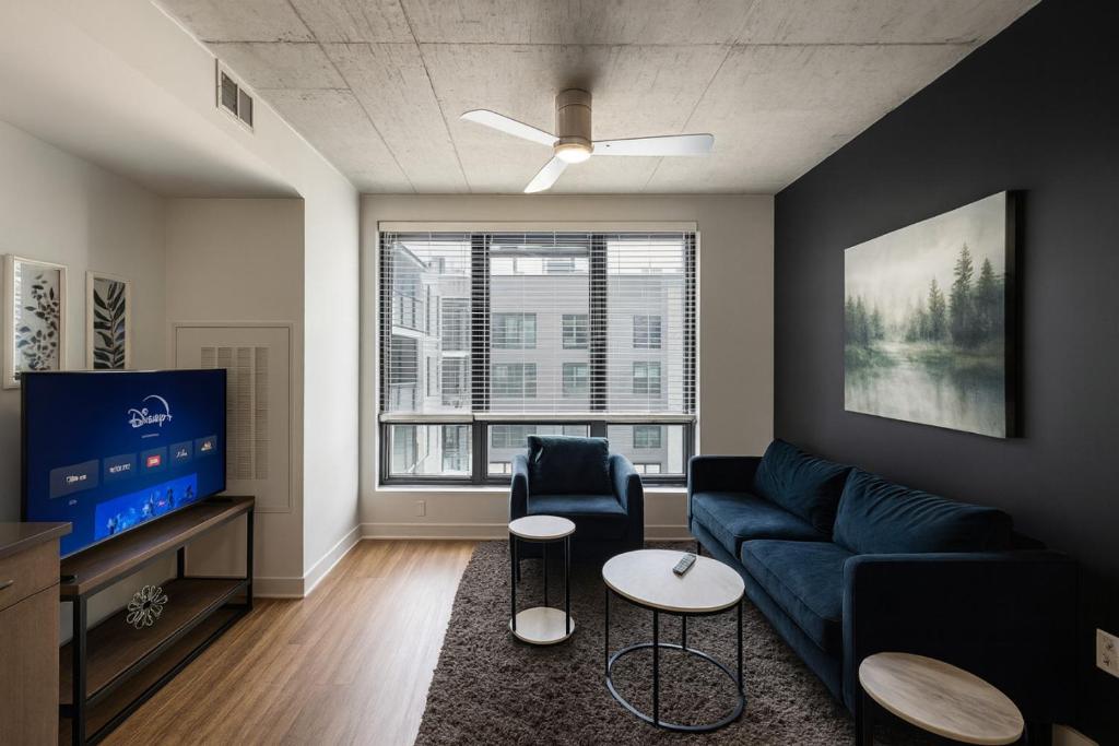 a living room with a blue couch and a tv at Five Points South Spacious 2BR with 2 Queens D5 in Birmingham