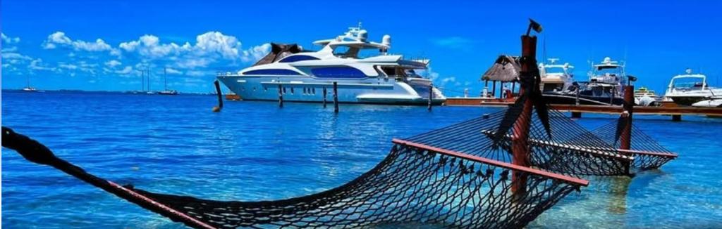 a boat is docked in the water with a hammock at Bahia Tolok in Isla Mujeres
