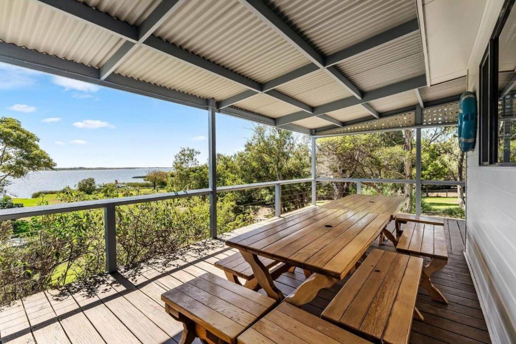 a picnic table on a deck with a view of the ocean at Spikes Place - Waterfront Serenity for Groups in Hindmarsh Island