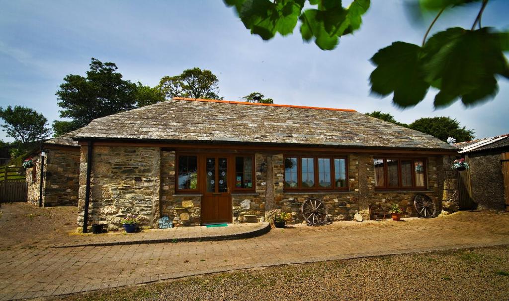 uma pequena casa de pedra com uma grande janela em The Old Wagon House em Saint Clether