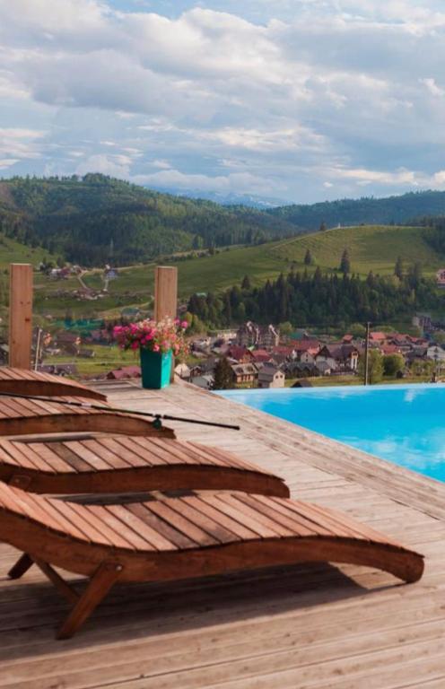 a wooden deck with a table with a view of a pool at Vysche Neba in Bukovel