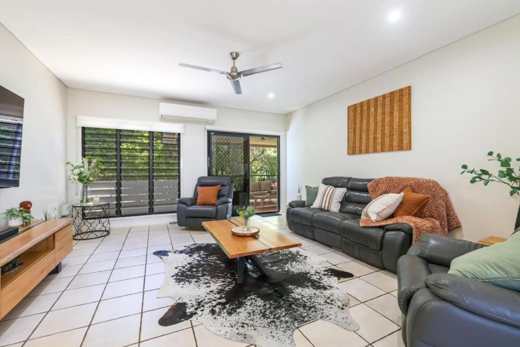 a living room with a couch and a table at Huge Stylish Townhouse in Stuart Park