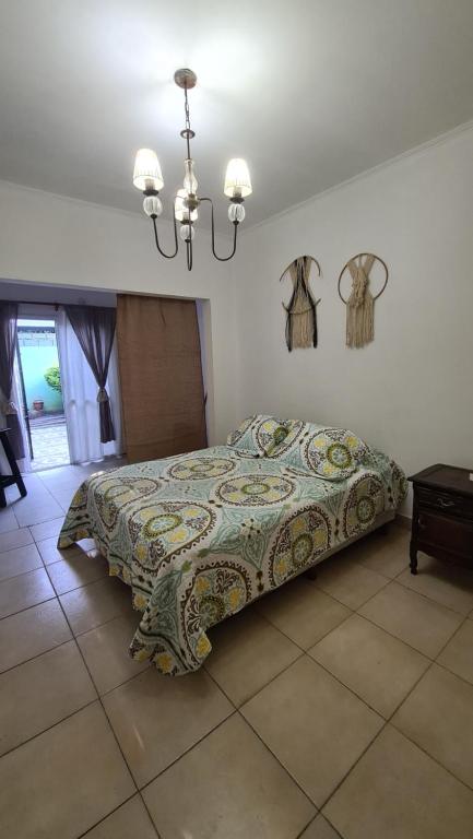 a bedroom with a bed and a chandelier at Depto Baires Oeste Merlo in Merlo