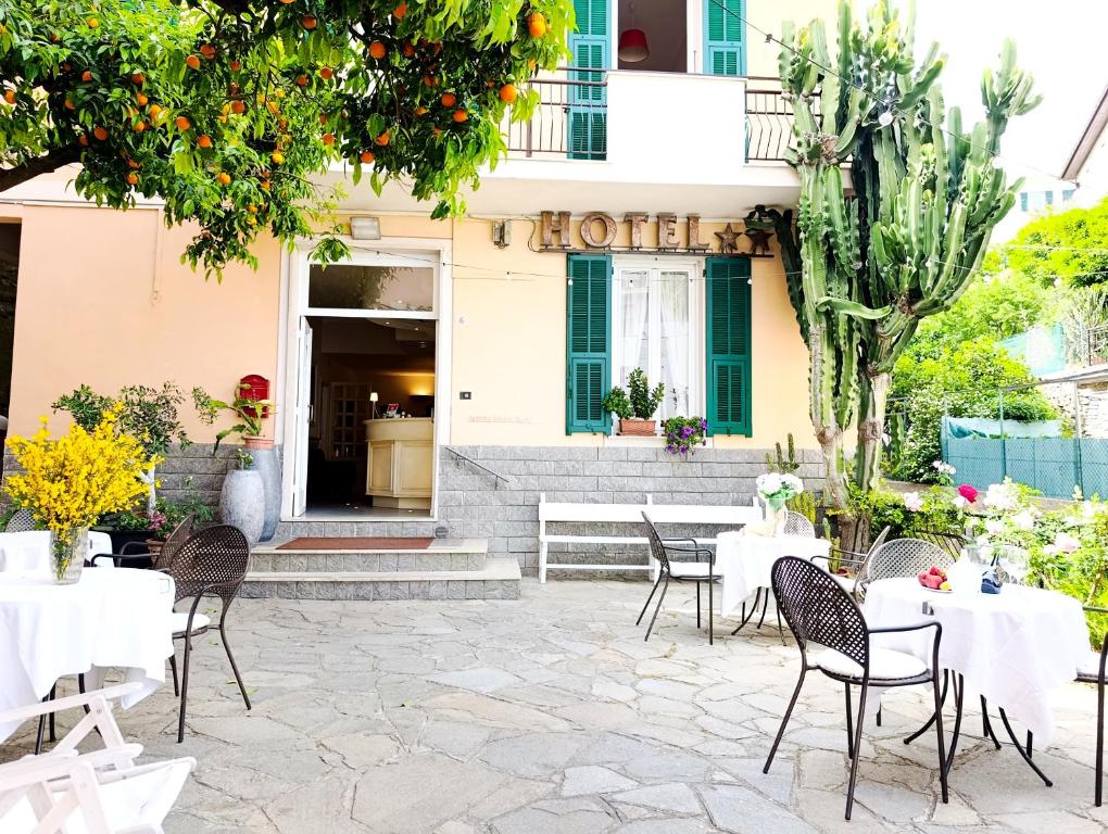 a restaurant with tables and chairs in front of a building at Hotel Villa Bianca in Laigueglia