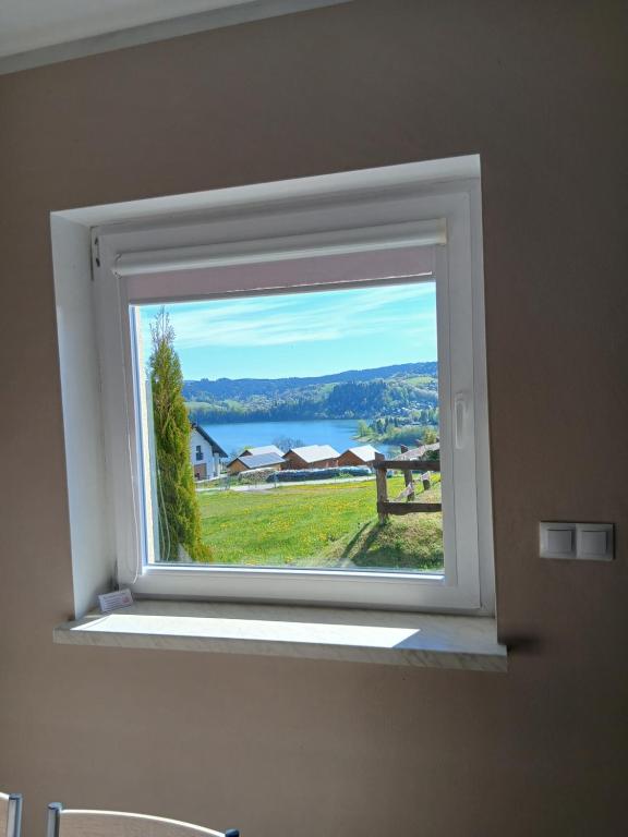 a window in a room with a view of a field at Tęczowe Wzgórze Bieszczady 887 - 507 - 298 in Wołkowyja