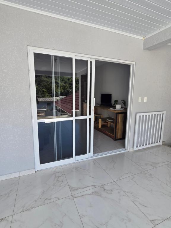 an empty room with a sliding glass door with a desk at Aconchego in Concordia