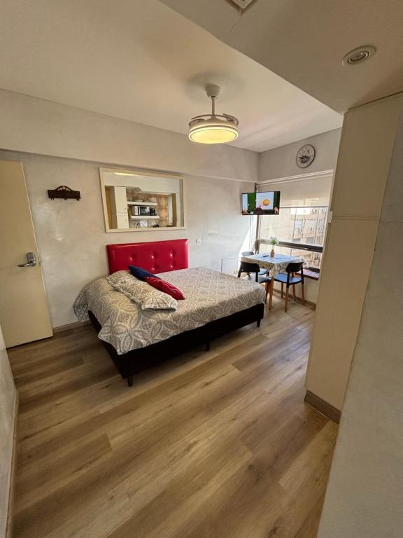 a bedroom with a bed with a red headboard and a table at Torre Obelisco - Apart 2 Amb en Av Corrientes, Buenos Aires, Argentina in Buenos Aires