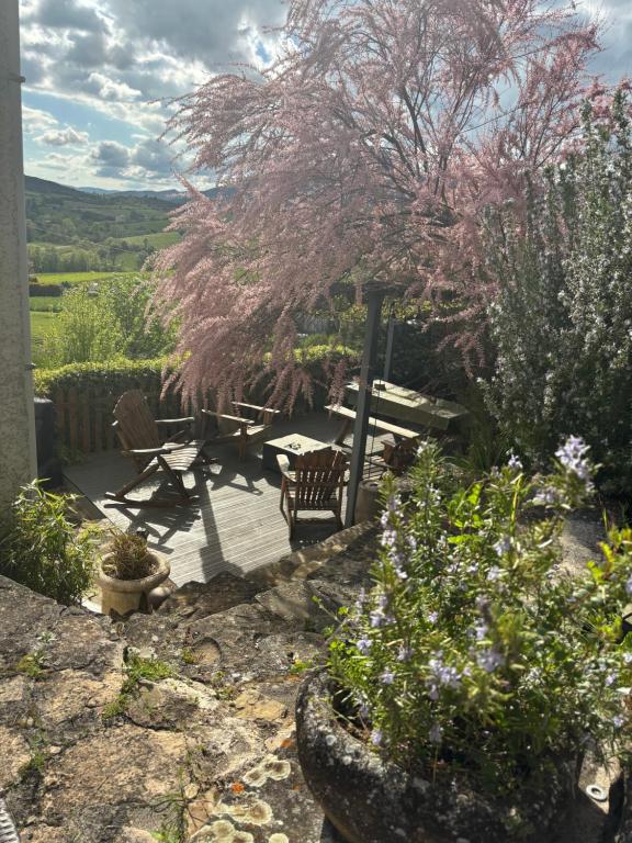 a patio with a table and chairs and flowers at Maison de Coco in LʼÉpine