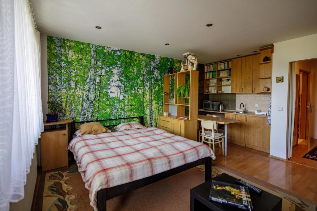 a bedroom with a large bed and a kitchen at Apartmán Brezy in Martinske Hole