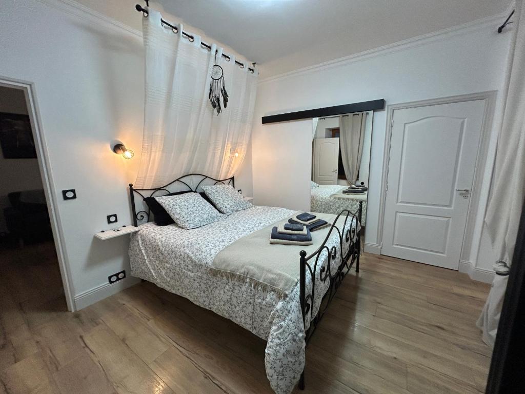 a bedroom with a bed with a black and white comforter at Maison d'hôtes et gîte - Les 4 saisons de Manon in Tourtoirac