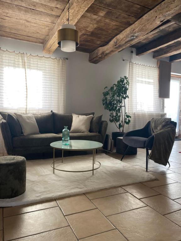 a living room with a couch and a table at Maison de campagne 110m2 in Longeault