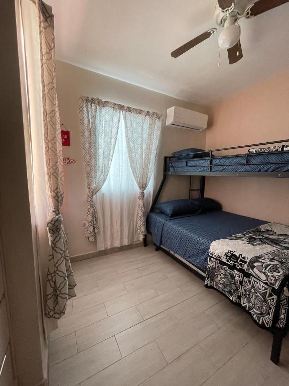a bedroom with two bunk beds and a window at Oasis in Montemorelos