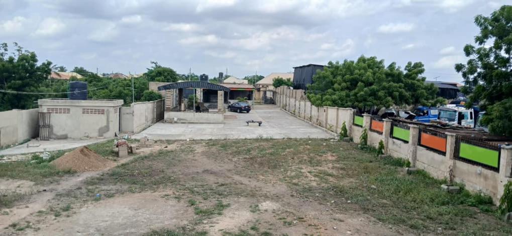 an empty yard with a fence and a dog at DeBoss Arena in Abeokuta