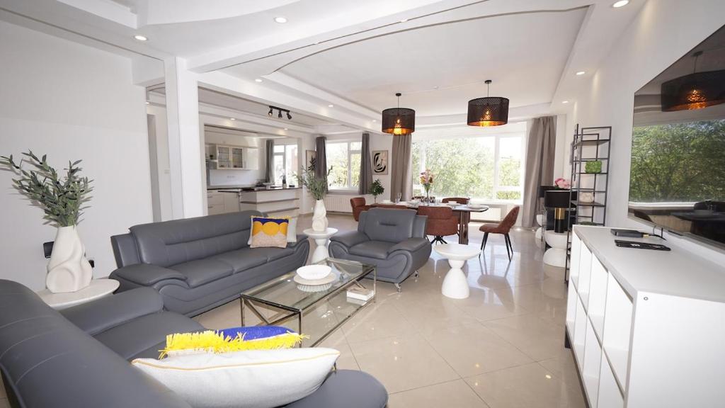 a living room with blue couches and a kitchen at Rubens Loft four bedrooms two bathrooms in Antwerp