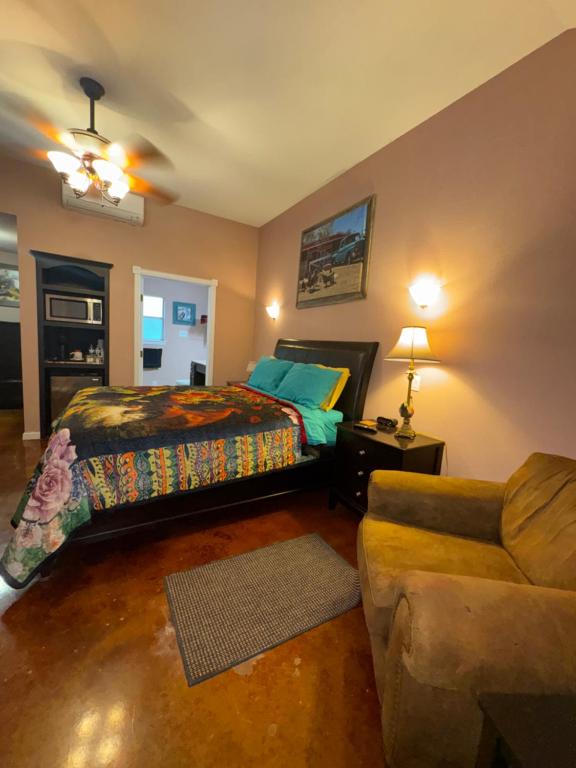 a bedroom with a bed and a couch at Cabin 4 The Roost Cabins in Lakehills