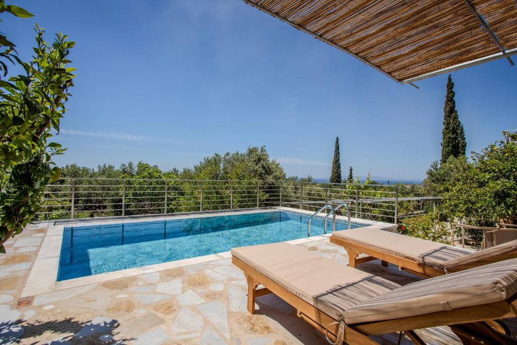 a swimming pool with two chaise lounges next to a swimming pool at Villa Aethra in Riglia