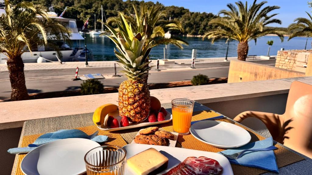 a table with a plate of food and a pineapple at SFE Apartment in Milna