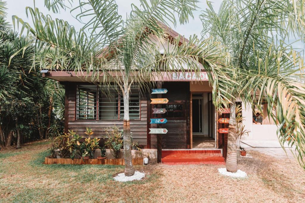 a small house with palm trees in front of it at Sacado Moorea Auberge de jeunesse Youth Hostel non climatisé no AC in Irioa