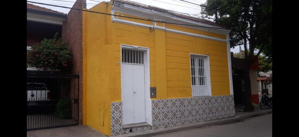 a yellow house with a white door on a street at 7 duendes in Salta