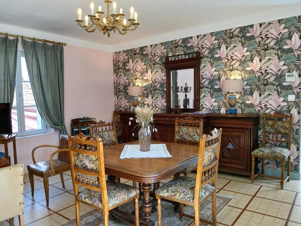 a dining room with a wooden table and chairs at La Georginette in Saint-Georges-sur-Cher