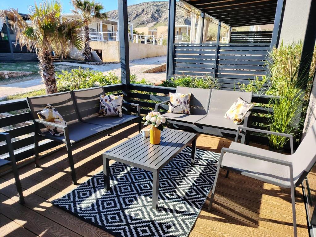 a patio with a table and chairs on a deck at Izzi Mobile Home - Terra Park SpiritoS in Kolan