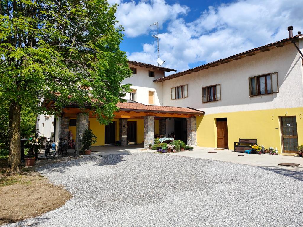 a large yellow and white house with a driveway at Casa Beuzer in Cividale del Friuli