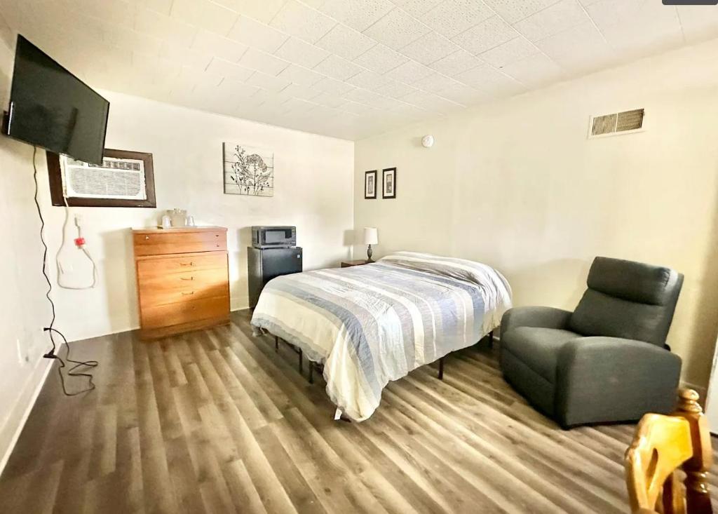 a bedroom with a bed and a chair at Flora Motel in Flora