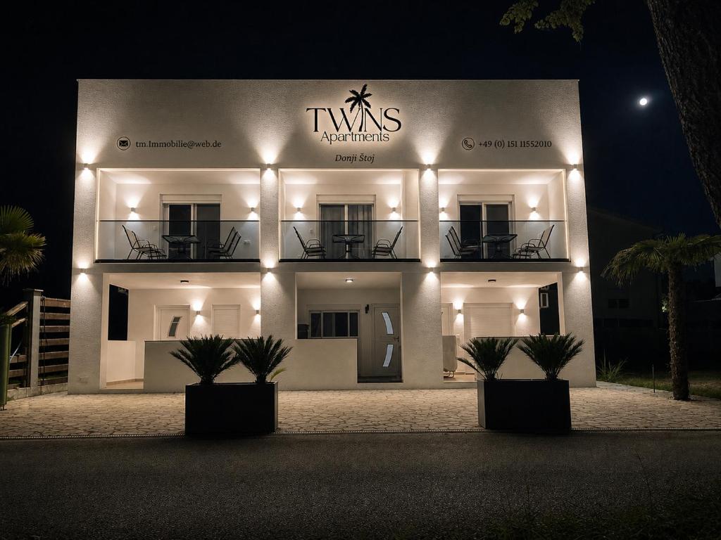 a large white building with lights on it at night at TWINS Apartments in Bregvija