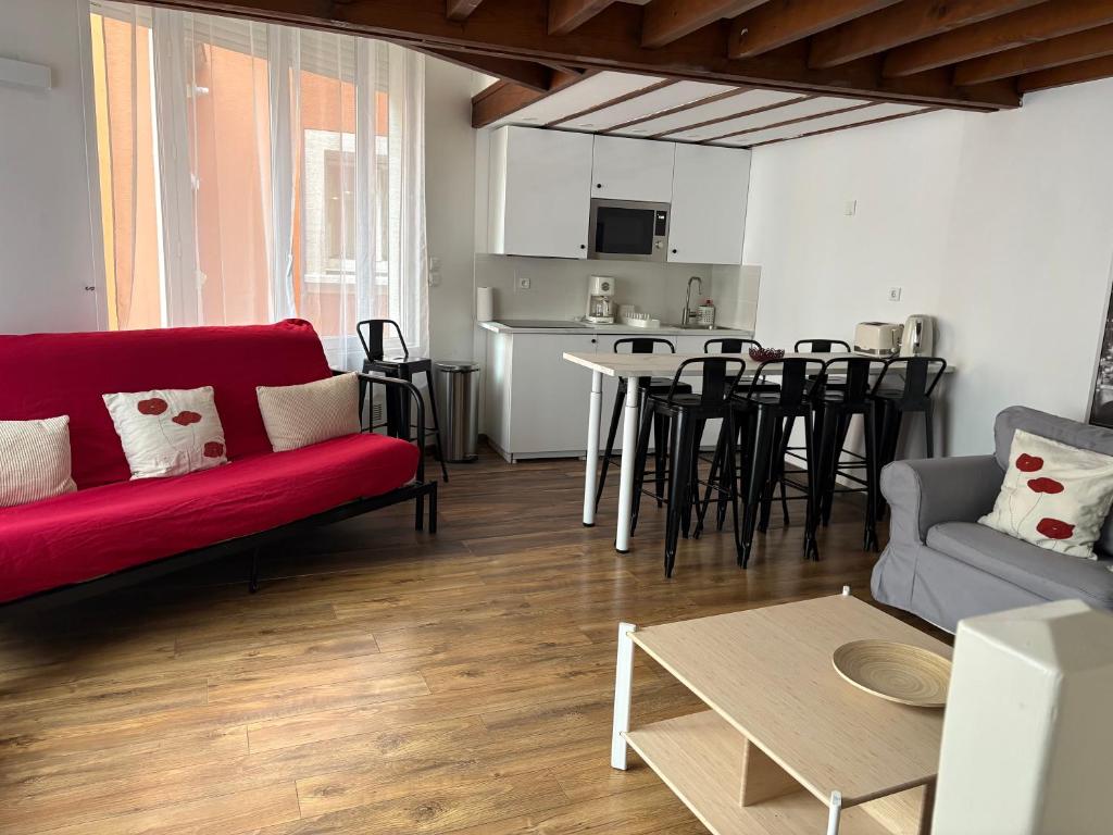 a living room with a red couch and a table at Marne appartements in Nogent-sur-Marne