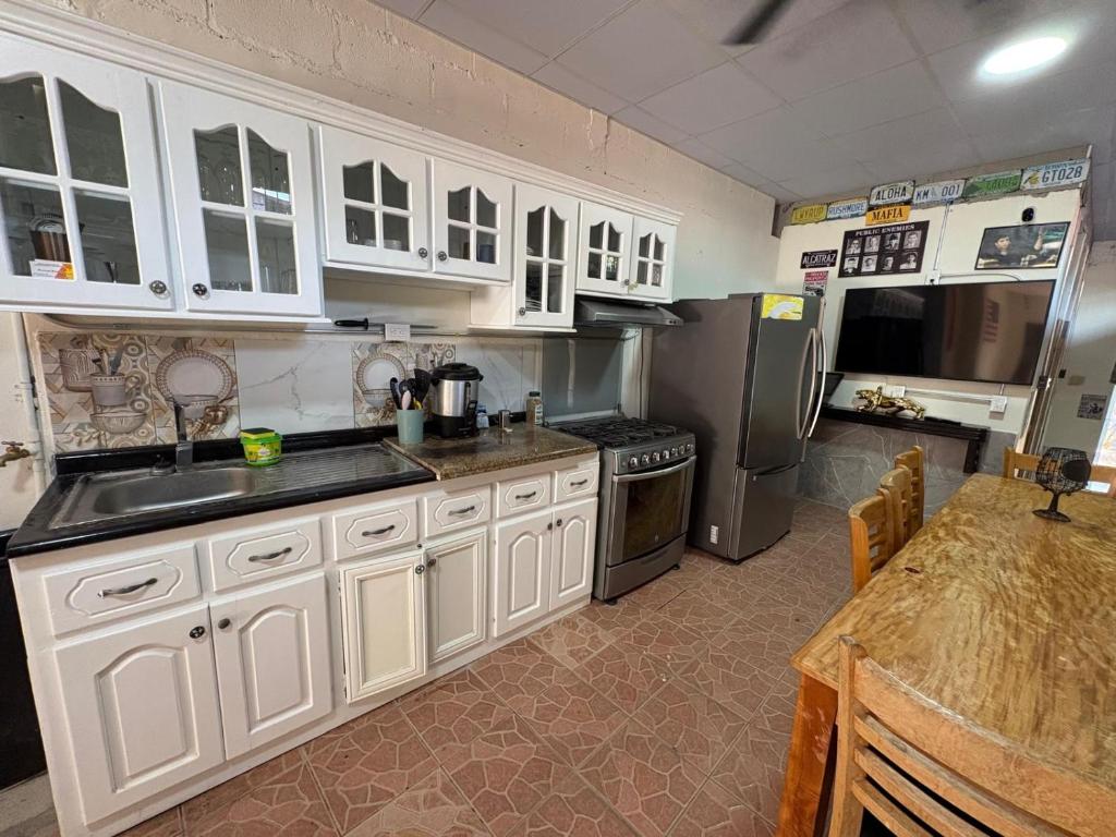 a kitchen with white cabinets and stainless steel appliances at Hostal Charlotte in La Unión