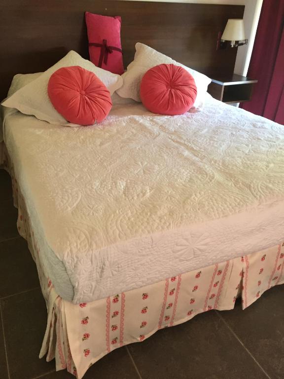 a bed with two red pillows on top of it at Complejo Puelo Altos de Golondrinas in Golondrinas