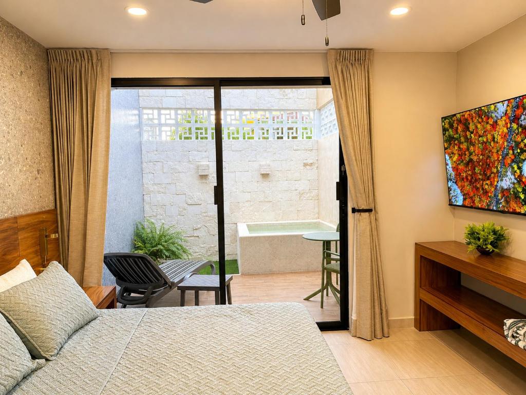 a bedroom with a bed and a bathroom with a tub at Suite Deluxe con piscina privada en Valladolid - Penca Leonor 11 in Valladolid