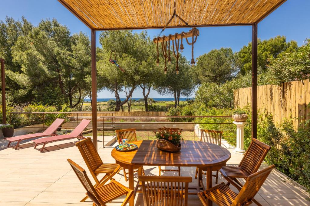 a patio with a wooden table and chairs at Villa Fefè in Nardò