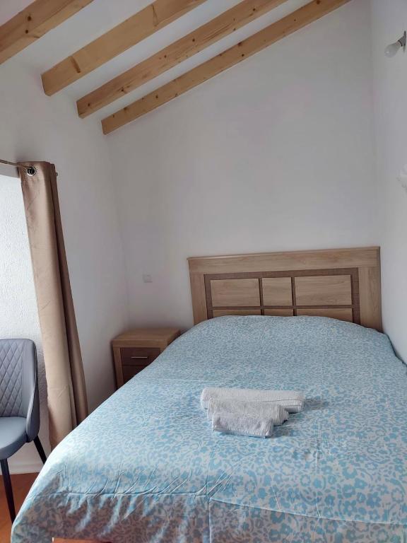 a bedroom with a bed with a blue comforter at Casa do Rio Alva in Caldas de São Paulo