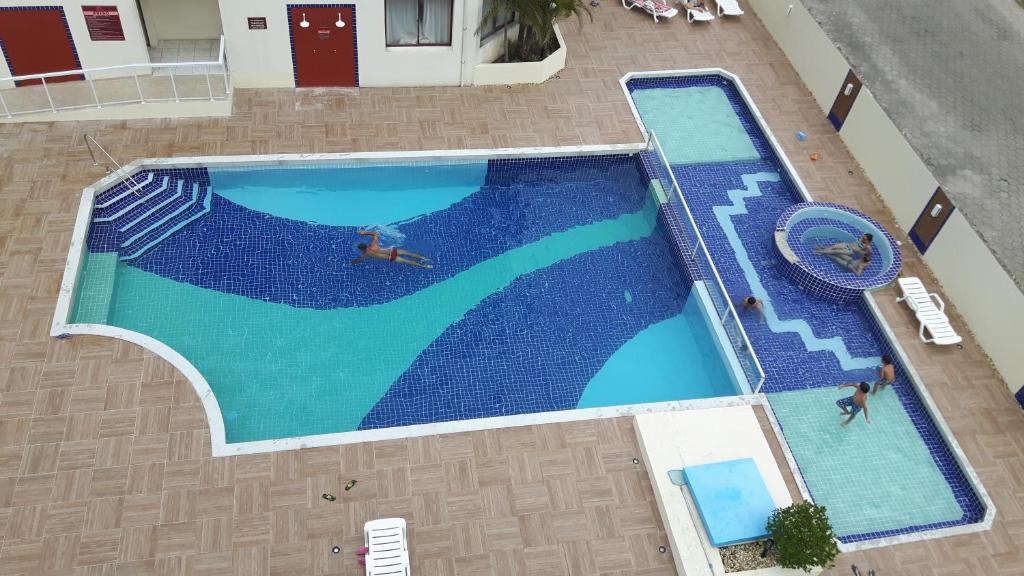 an overhead view of a large swimming pool with people in it at Apto Ingleses à 50mts da praia in Florianópolis