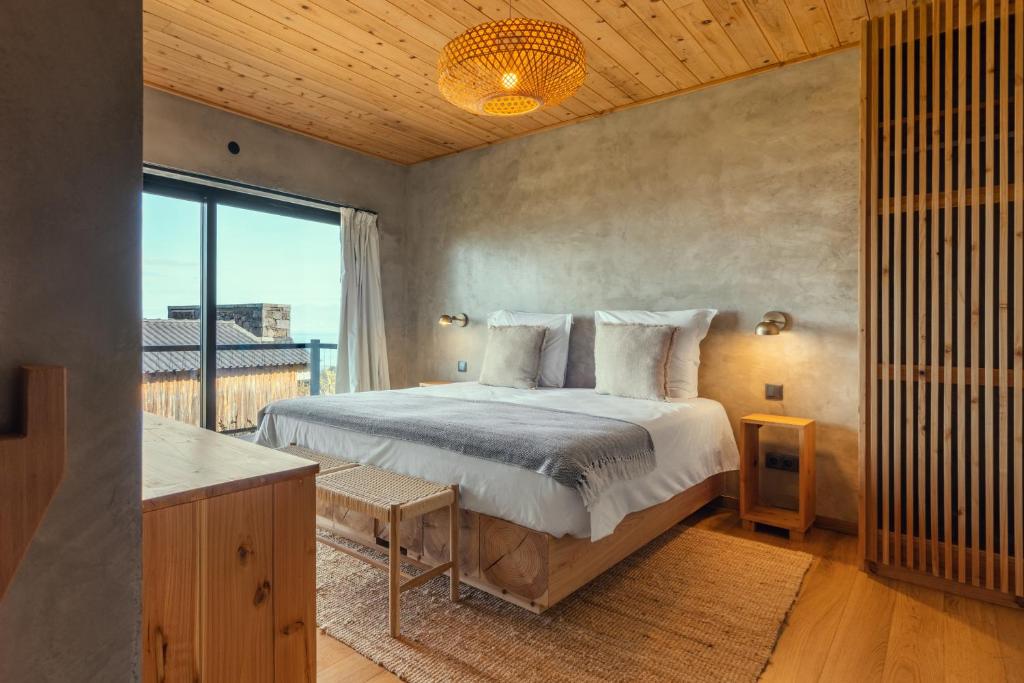a bedroom with a bed and a large window at Casa da Rocha in Terra Alta