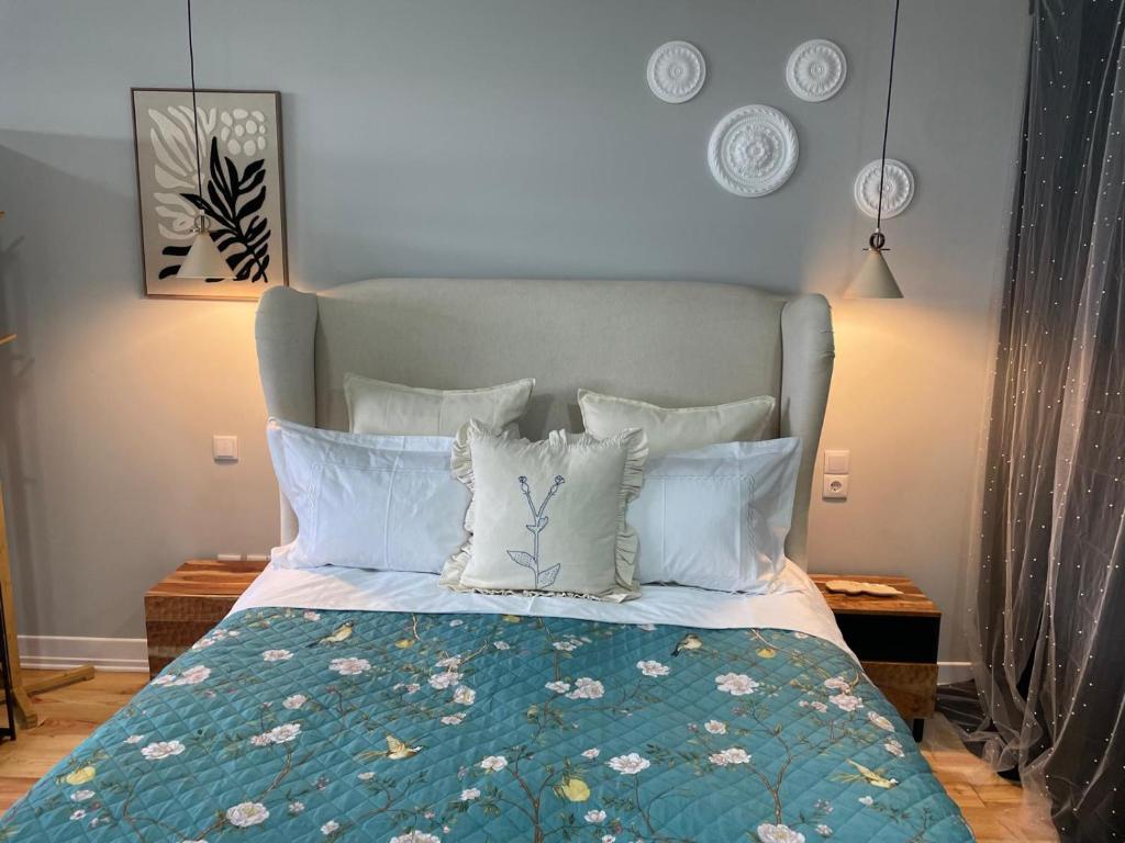 a bedroom with a bed with a blue headboard and pillows at Salina Ria Studio 2 in Aveiro