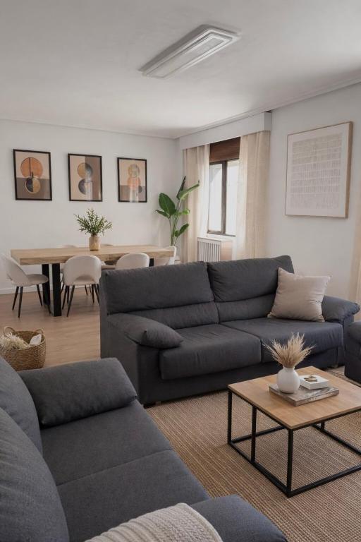 a living room with a blue couch and a table at Entre Plazas in Cáceres